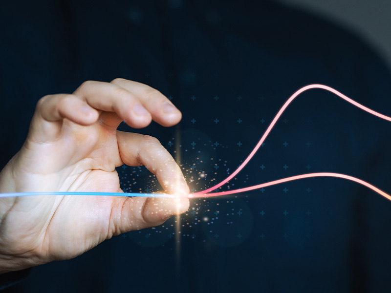 Hand holding glowing energy lines, symbolising the cost savings, flexibility, and risk management benefits of basket energy procurement.