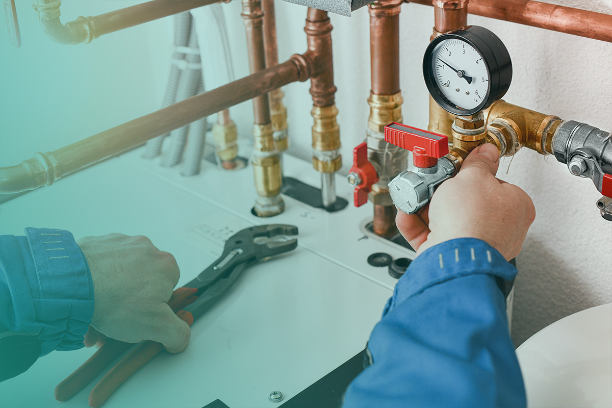“Engineer adjusting valves and gauges during Disconnection, Reconnection, Upgrades and Downgrades of commercial heating and pipework systems.”