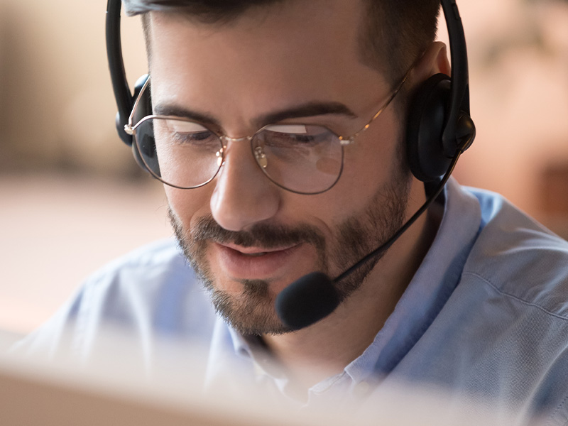 Smiling professional with a headset providing client support, representing expert guidance in delivering AMR energy meters and BMS audits.