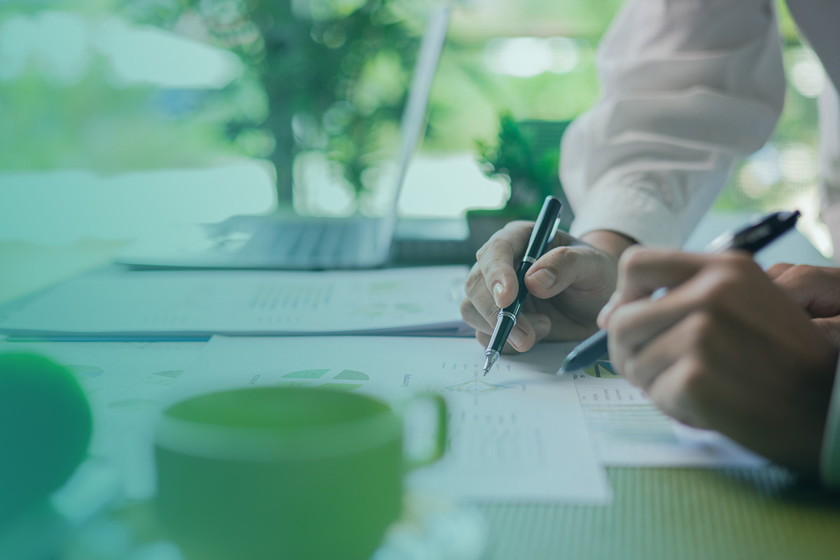 “Two people reviewing documents and charts as part of developing detailed Life Cycle Plans for a commercial building.”