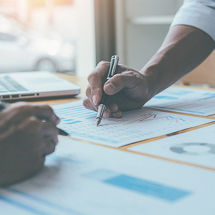Close-up of professionals reviewing charts and graphs during an Energy audit consultation.