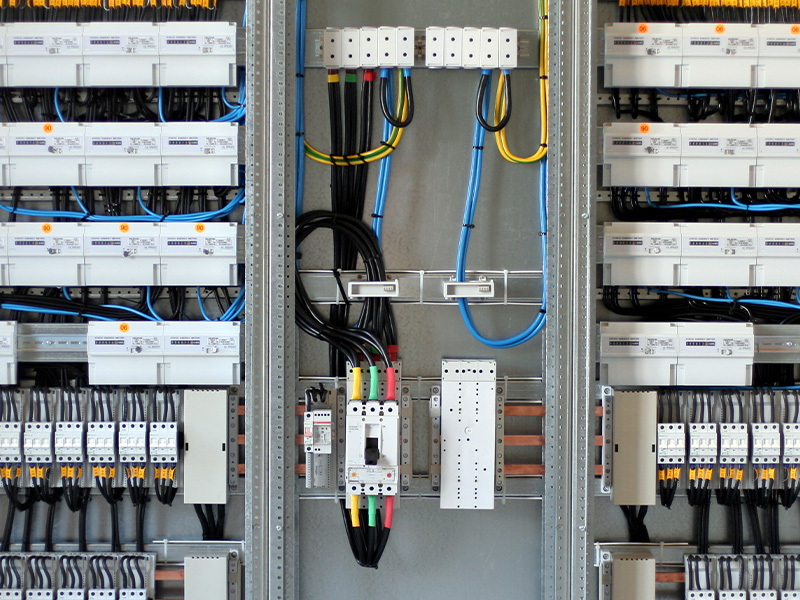 Close-up of an electrical control panel with wiring and metering systems, representing the role of AMR energy meters and BMS audits in building efficiency.