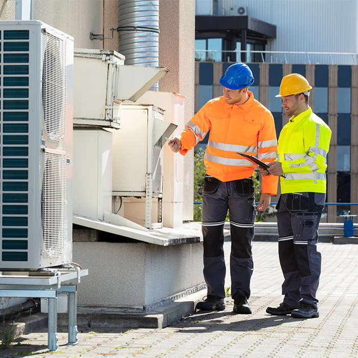 Engineers performing a tm44 inspection on a commercial rooftop air conditioning unit.