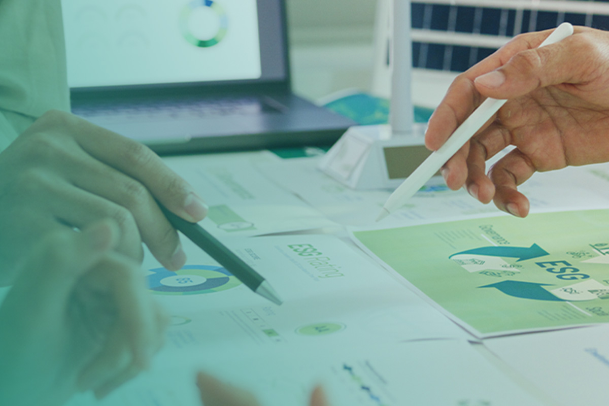 “Hands reviewing sustainability charts and reports on a desk, representing SECR Compliance Services.”