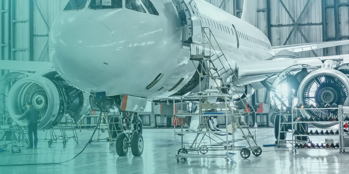 Aircraft undergoing maintenance in a hangar, representing aviation sector efforts toward SECR compliance and carbon reporting.