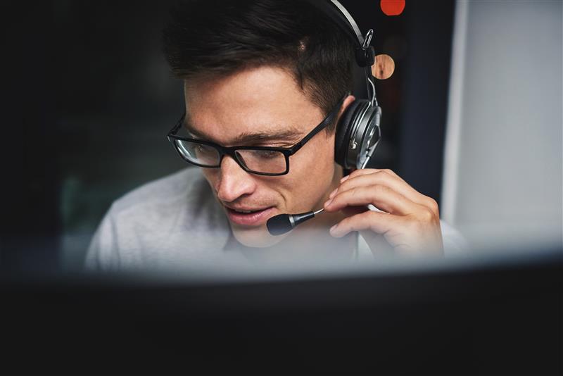 Energy advisor speaking with a client during a free energy procurement strategy call, wearing a headset in a professional setting.