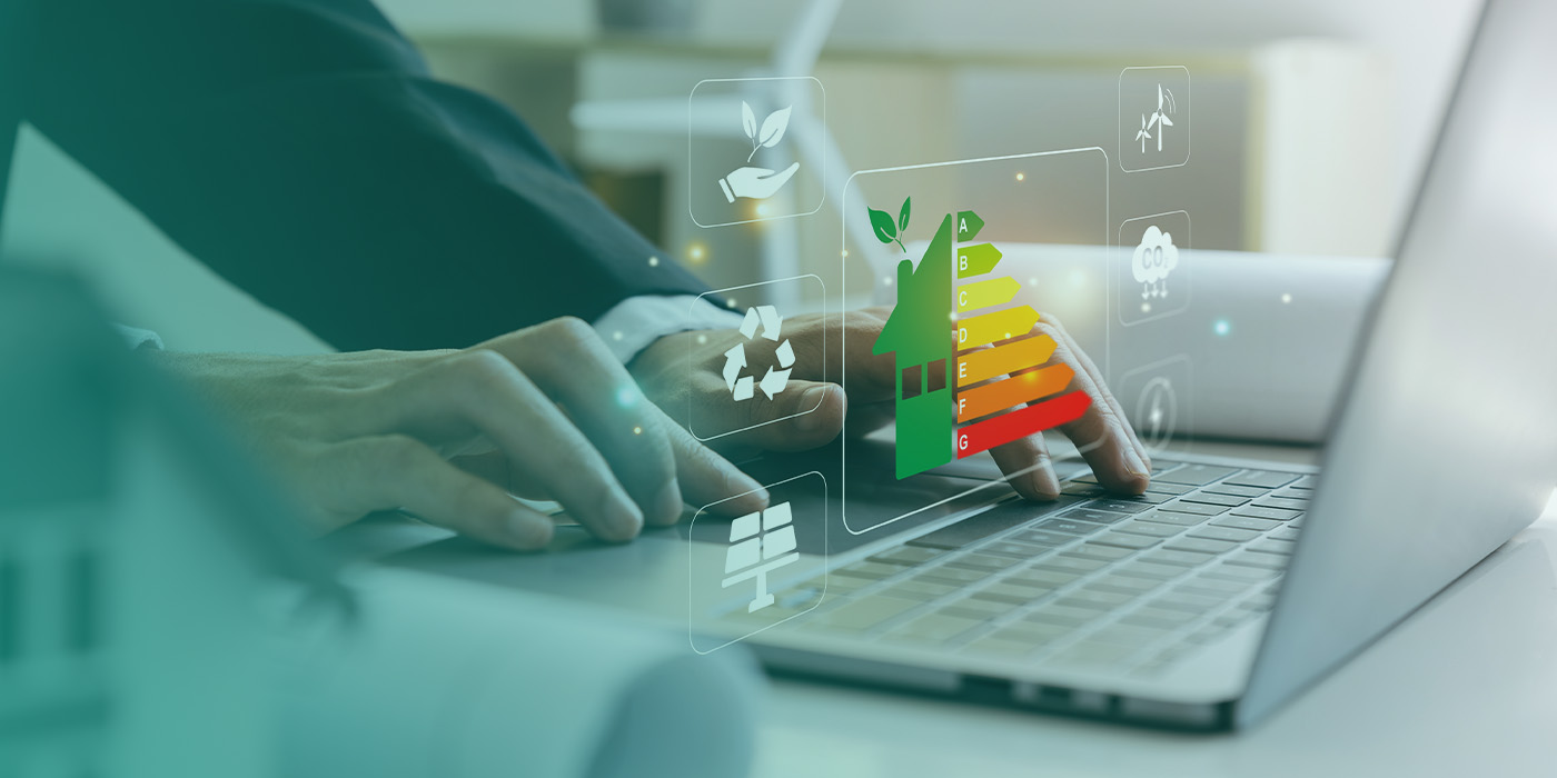 Person using a laptop with digital sustainability icons and an energy efficiency rating graphic, symbolising strategies and technologies driving the energy market 2025.