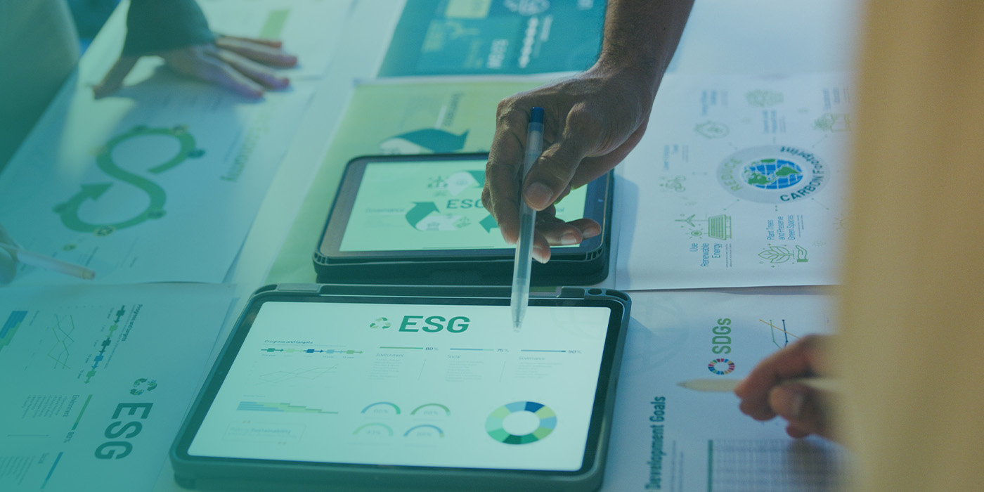 Professionals analysing ESG data on digital devices to demonstrate how the Smart Metering Toolkit for Landlords & Developers supports Net Zero and energy resilience goals.