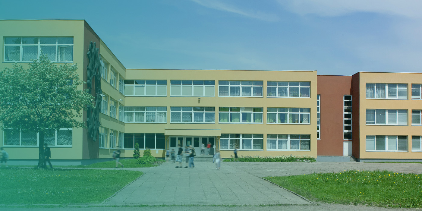 Exterior of a modern school building with students outside, illustrating how BMS Optimisation supports comfort, safety, and energy efficiency in education and public buildings.