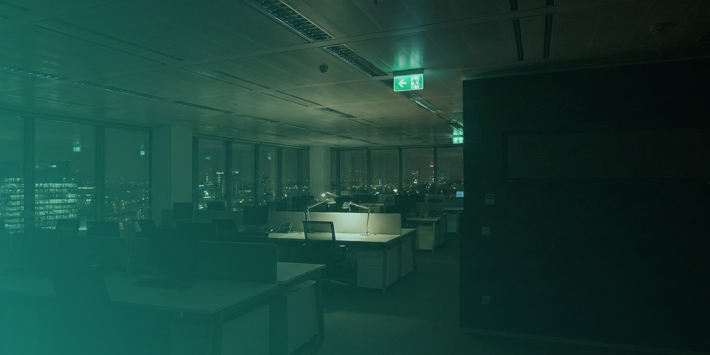 Empty office at night with lights still on, highlighting how organisations can reduce energy bills through energy monitoring by identifying out-of-hours waste.